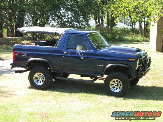 1982 Ford Bronco with a blue exterior and a removable soft top, lifted with off-road tires