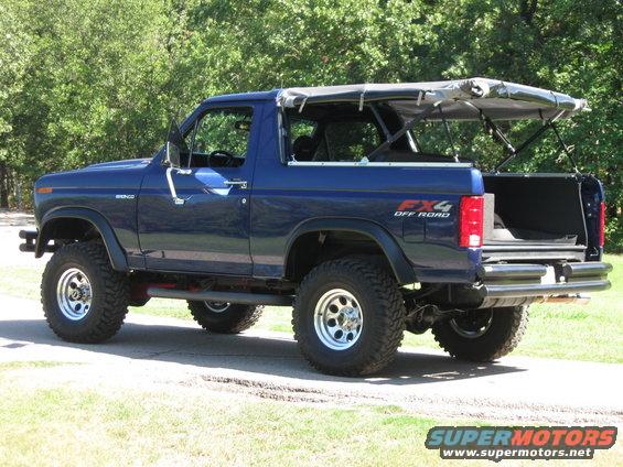 Blue Ford Bronco with a soft top, lifted with off-road tires. Has FX4 badging