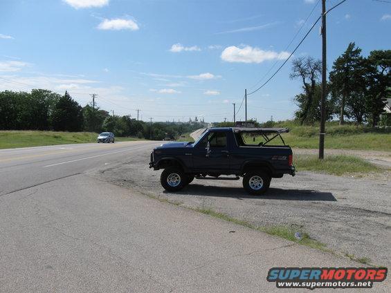 Dark blue SUV parked on the side of a road, with a removable top and off-road tires