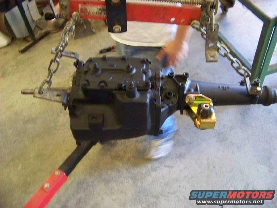 Transmission and rear axle assembly being worked on with chains and a red support