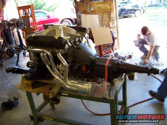 Engine and transmission assembly with chrome headers on a stand