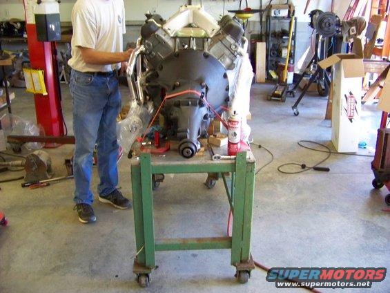 Engine on a green rolling stand in a workshop