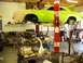 1974 Dodge Challenger - A lime green muscle car is suspended on a lift in a garage, with its engine removed and various tools and parts scattered around.