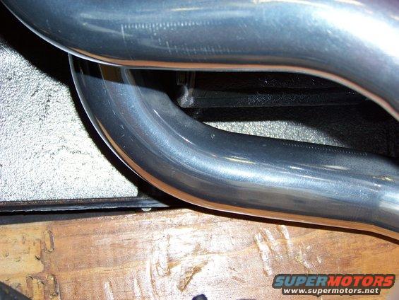 Close-up of polished exhaust pipes over wooden planks