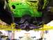 1974 Dodge Challenger - Underside view of a 1974 Dodge Challenger's engine bay, painted bright green and suspended on a yellow lift.