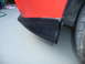 1993 Mazda MX-3 - Close-up of a red car's rear bumper corner, showing black trim and a tire.