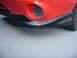 1993 Mazda MX-3 - Close-up of a red car's front bumper, a black lip and an oval mesh grille.