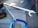 1993 Mazda MX-3 - Car parts, including a blue tool and a white strut bar, are stored in the trunk of a vehicle.