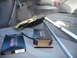 1993 Mazda MX-3 - Parts and tools are laid out in the cargo area of a vehicle.