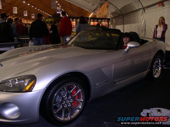 Silver convertible sports car with red brake calipers and a Viper badge on the side