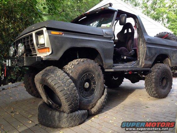 Modified 1978 Ford Bronco with large off-road tires, one spare tire visible