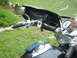 1998 Honda Shadow VT750C - Close-up view of motorcycle handlebars, a speedometer, mirror, and a leather pouch attached to the windshield.