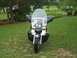 1998 Honda Shadow VT750C - A motorcycle is parked on a grassy area with trees and other vehicles in the background.