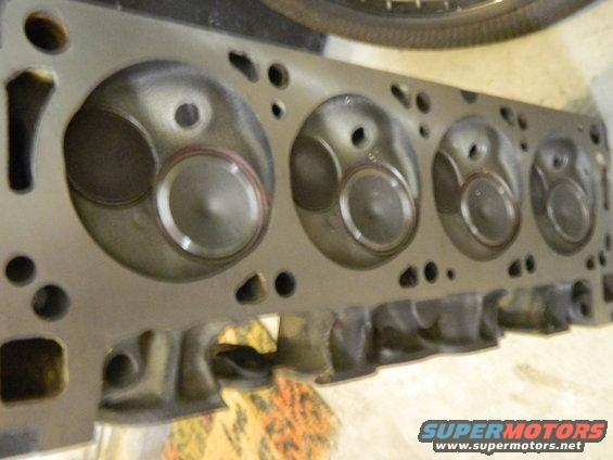 Engine cylinder head with multiple combustion chambers and valve openings