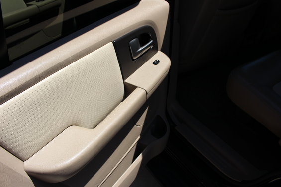 Interior door panel with tan leather insert and chrome handle