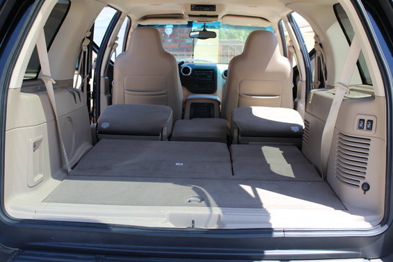 Tan interior of a 2003 Ford Expedition with folded rear seats and cargo area