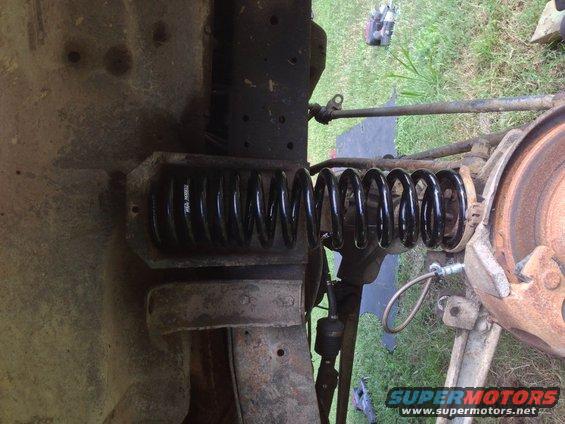 Vehicle suspension spring and brake assembly, showing rust and wear