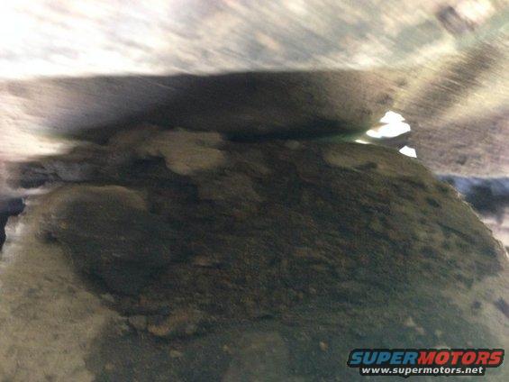 Underside of a vehicle, showing dirt and debris. Supermotors.net logo visible