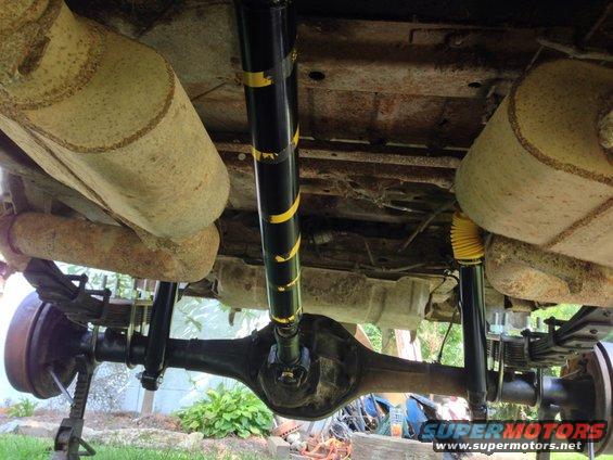 Undercarriage of a 1979 Ford Bronco, showing rear axle, leaf springs, dual exhaust, and driveshaft
