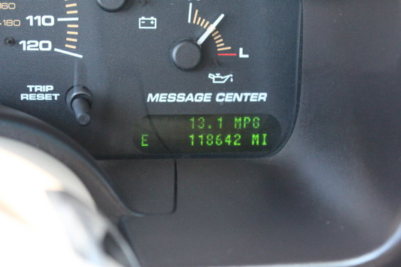 Dashboard gauges showing 13.1 MPG and 118,642 miles