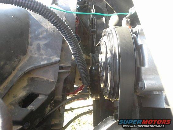 Close-up of engine belt and pulley system, possibly AC compressor