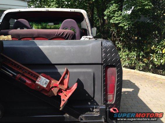 Rear of a 1979 Ford Bronco with racing seats visible inside and a Hi-Lift jack in the bed