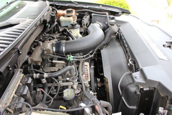 2003 Ford Expedition engine bay with air intake tube and fan shroud visible