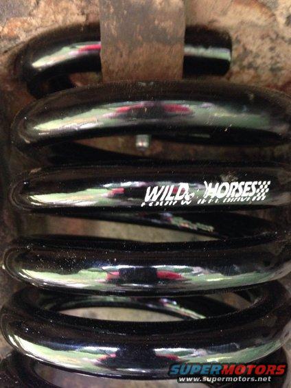 Black suspension coil spring with "WILD HORSES" text and checkered flag logo
