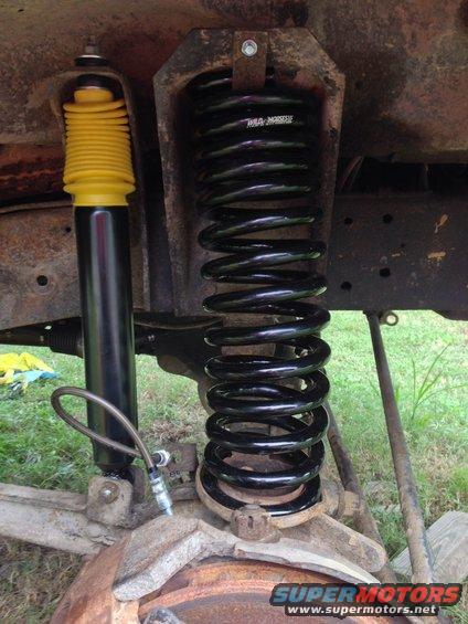 Front suspension part: new coil spring and yellow-capped shock absorber