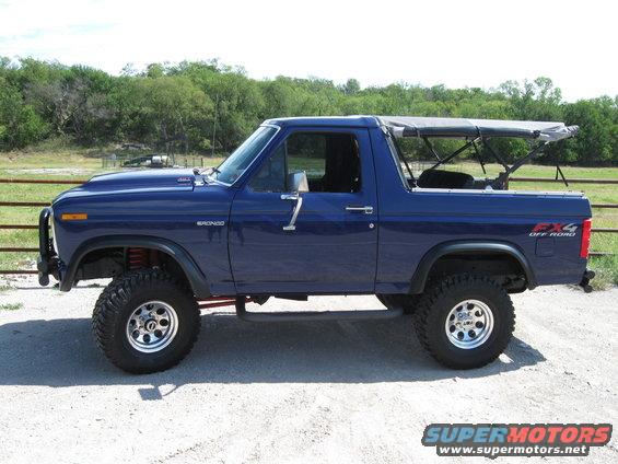 Blue Ford Bronco with a soft top, lifted suspension, and off-road tires. Visible FX4 badging on the rear fender