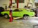 1974 Dodge Challenger - A lime green 1974 Dodge Challenger is shown on a lift in a garage, with its hood and trunk open for service.