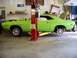 1974 Dodge Challenger - A lime green 1974 Dodge Challenger is shown on a lift in a garage, undergoing maintenance.