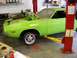 1974 Dodge Challenger - A lime green 1974 Dodge Challenger is shown on a car lift in a garage, with its front wheel off.