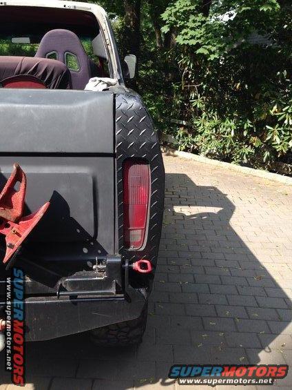 Rear of 1979 Ford Bronco with diamond plate fender trim and red tow hook