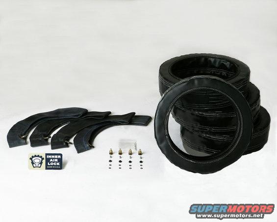 Four black inner tubes and four valve stems with a stack of black tire covers