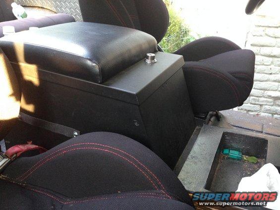 Black seats with red stitching and a black center console in a vehicle interior