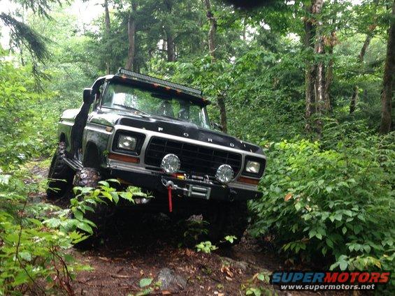 Black 1978 Ford Bronco off-roading with a winch and light bar