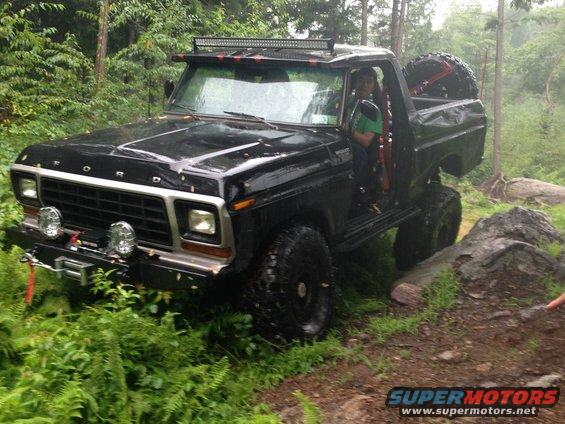 1979 Ford Bronco off-roading, black with spare tire on back