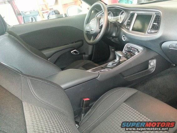 Interior view of a 2015 Dodge Challenger showing the dashboard, steering wheel, center console, and seats