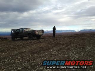 Rear view of a camouflage Ford pickup truck in a desolate landscape
