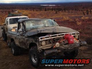 Damaged pickup truck with a red gas can mounted on the front, another truck behind it