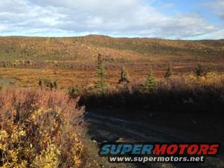 Dirt road through a fall landscape with SuperMotors watermark