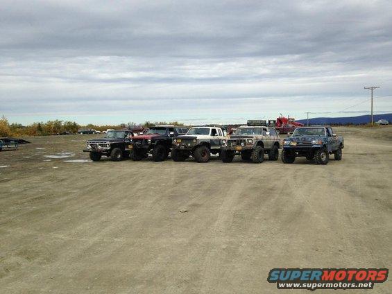 Line of lifted off-road trucks parked in a lot