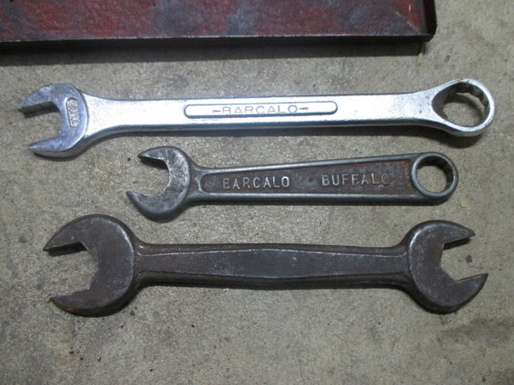 Three wrenches on a concrete surface, one is shiny and marked "BARCALO", another is rusty and marked "BARCALO BUFFALO", and the third is heavily rusted