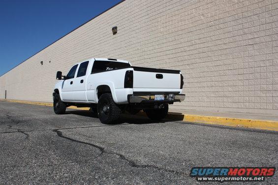 White pickup truck with tinted taillights and aftermarket wheels parked on asphalt