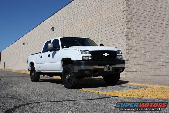 White pickup truck parked outside a building. License plate says CAT