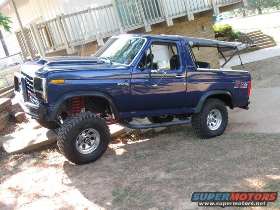 Blue Ford Bronco with lifted suspension and off-road tires, parked outdoors