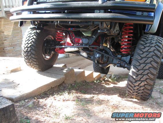 Off-road vehicle front suspension with red shocks and springs