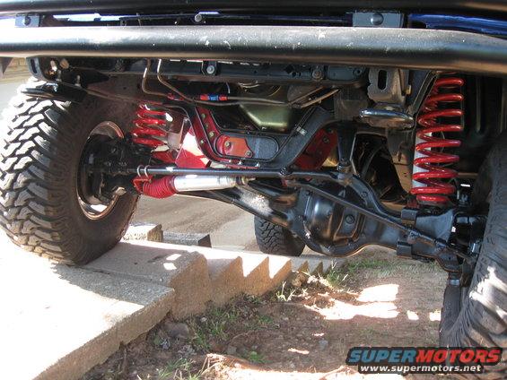 Close-up of off-road vehicle's front axle, suspension, and shock absorber