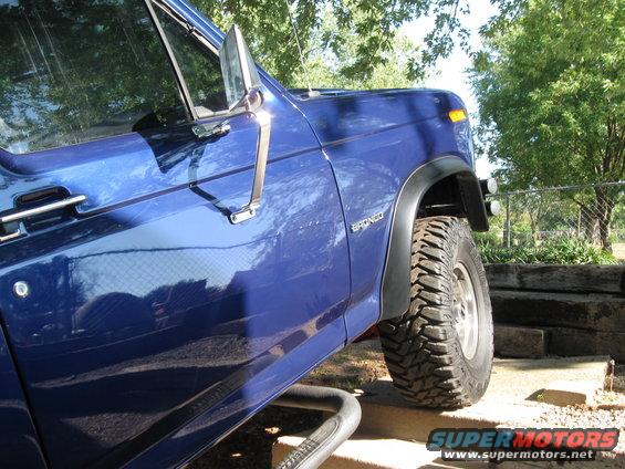 Blue Ford Bronco with off-road tires, seen from the front quarter angle